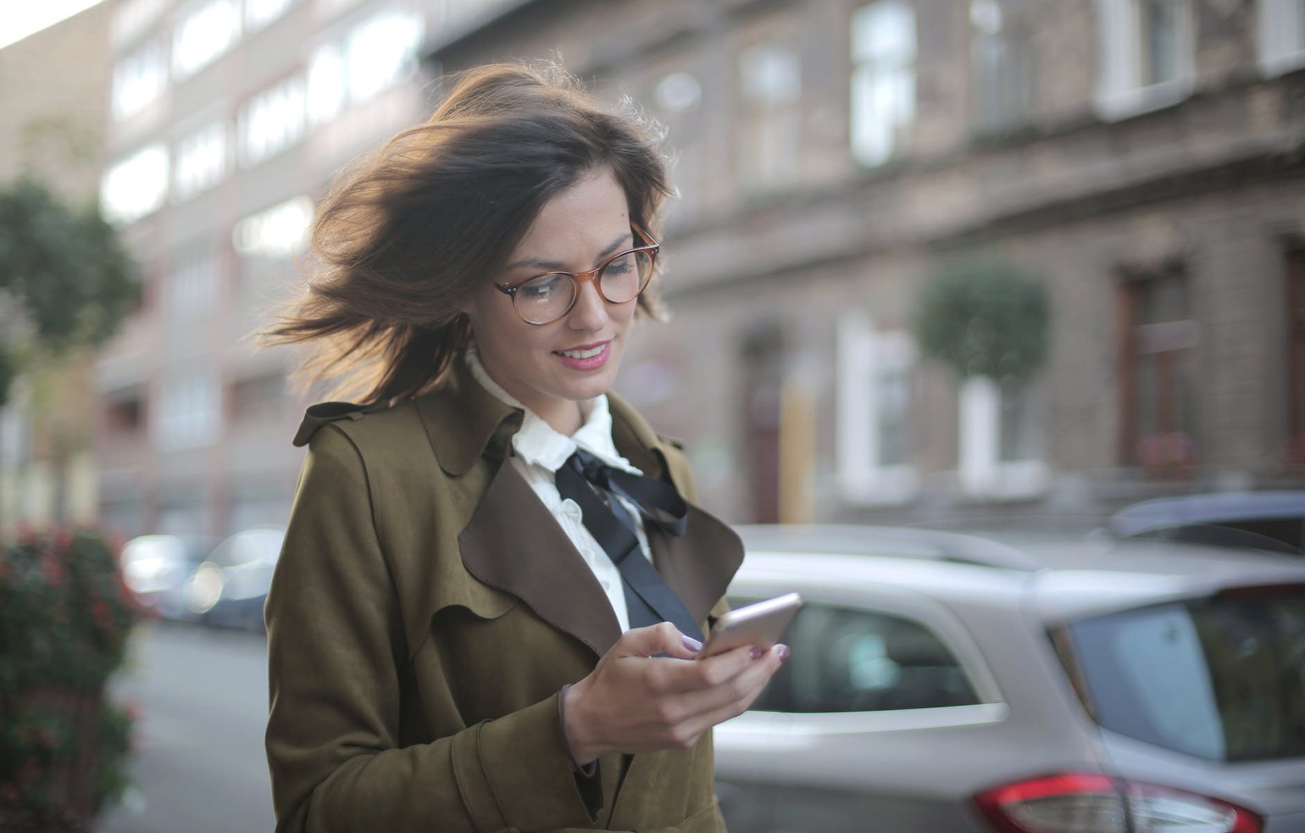 stylish adult female using smartphone on street