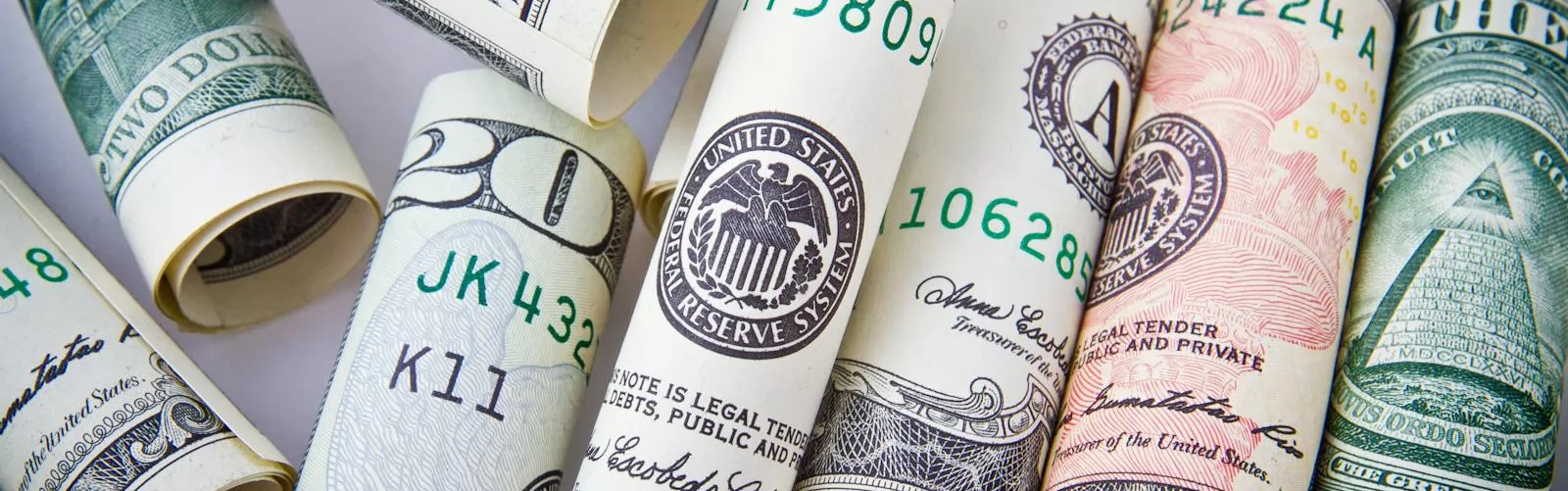 Close-up of rolled US dollar bills symbolizing wealth, financial success, and currency.